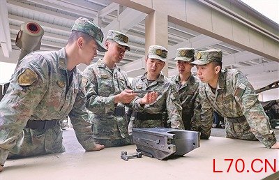 “英雄炮兵连”二级上士胡发山（左二）为普通连队战士讲解火炮炮闩分解结合要领南京证券配资服务中心。王群淇摄